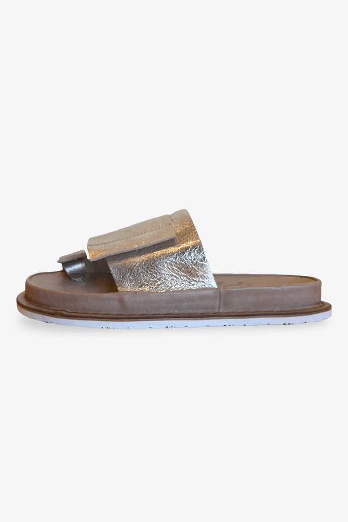 A geometrically overlapping unisex thong sandal. Leather inner sole and soft metallic leather upper with rubber bottom. side product shot